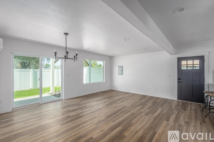 A room with wooden flooring and a chandelier.