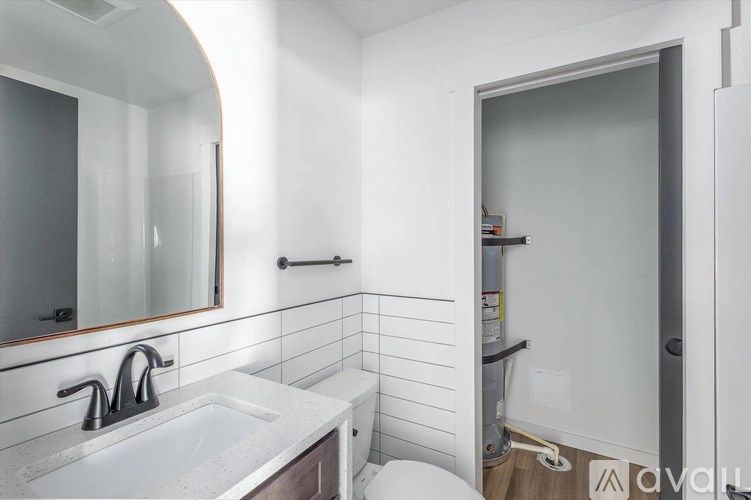 A bathroom with a sink, mirror, and toilet.