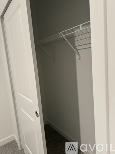 A white door with a small round knob and a white wall.