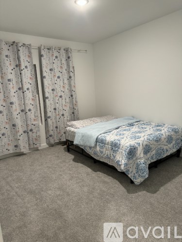 A bedroom with a bed and curtains.