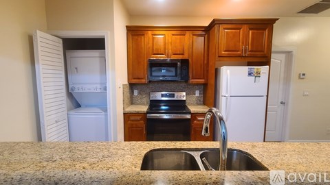 A kitchen with a sink, refrigerator, and microwave.