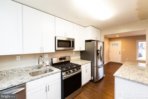 A kitchen with white cabinets and a granite countertop.
