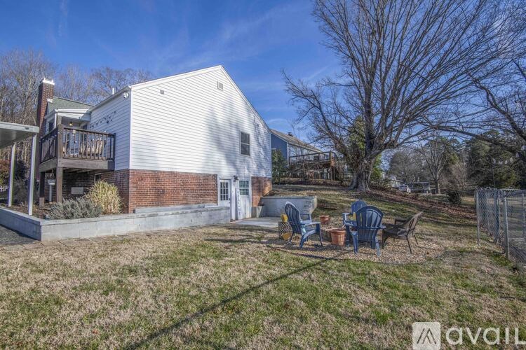 A house with a white siding and a deck with chairs.