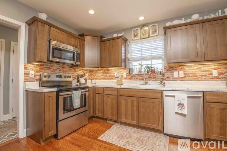 A kitchen with wooden cabinets and a brick backsplash.