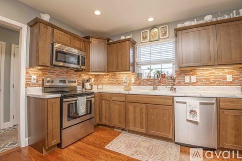 A kitchen with wooden cabinets and a brick backsplash.