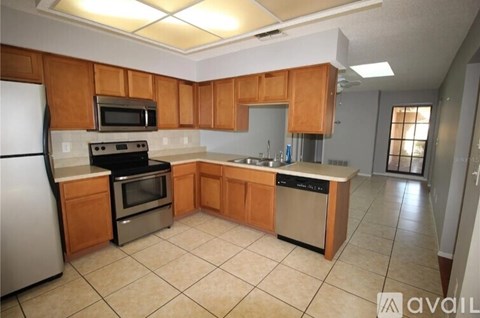A kitchen with wooden cabinets and a white refrigerator.