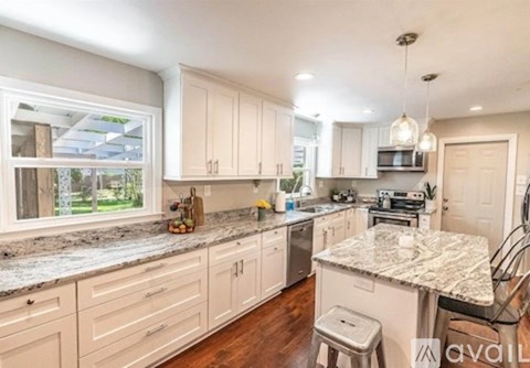 A kitchen with white cabinets and a granite countertop.