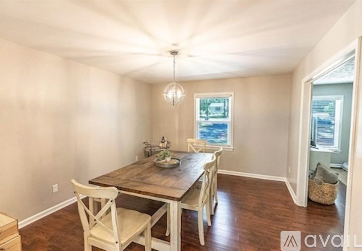 A dining room with a wooden table and chairs.