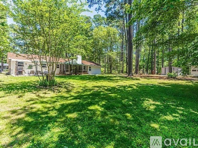A house is surrounded by trees and grass in the yard.