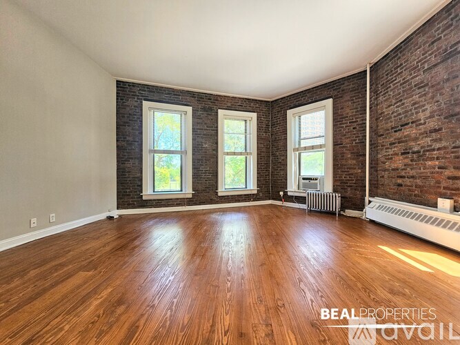 A living room with a brick wall and a fireplace.