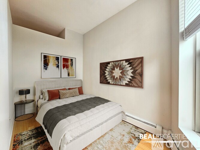 A bedroom with a large bed and a starburst patterned picture on the wall.