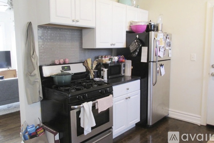 A kitchen with black and white appliances and white cabinets.