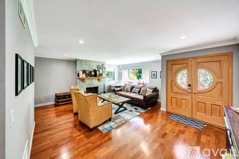 A living room with a tan couch and a wooden floor.