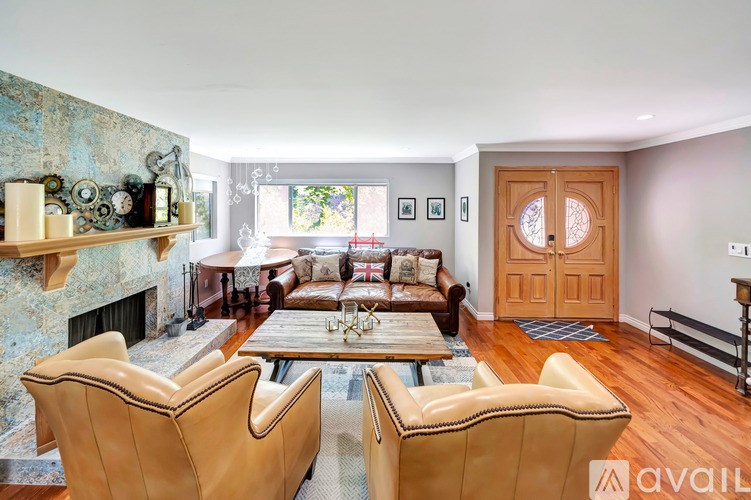 A living room with a fireplace and two chairs.
