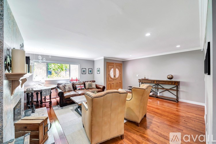 A living room with a tan couch and a fireplace.