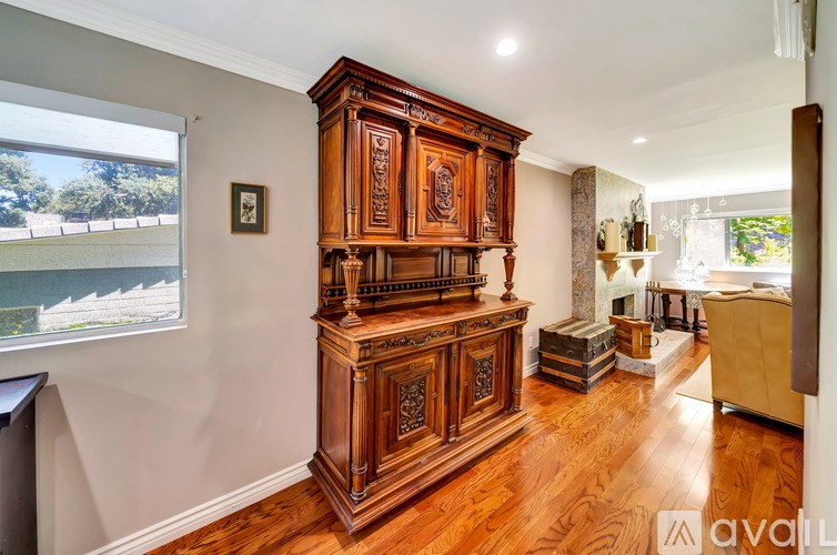 A large wooden cabinet with intricate carvings is the focal point of the room.