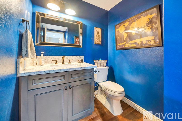 A bathroom with blue walls and a white toilet.