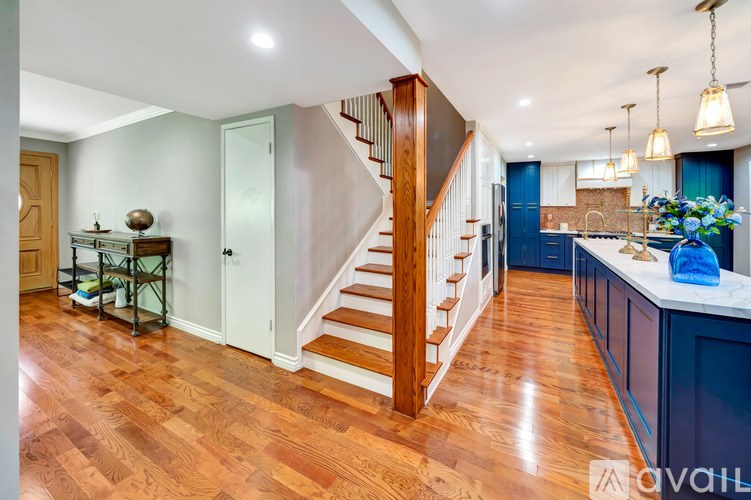 A wooden staircase leads to a second floor with a kitchen area below.
