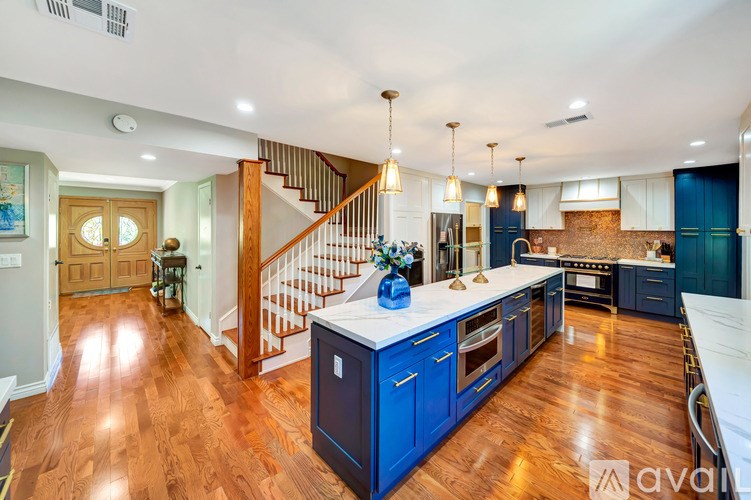 A kitchen with blue cabinets and a wooden floor.