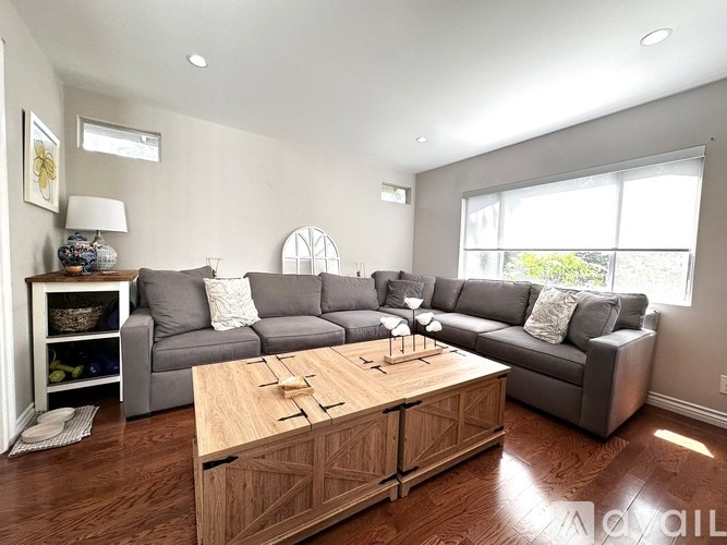 A living room with a grey couch and a wooden coffee table.
