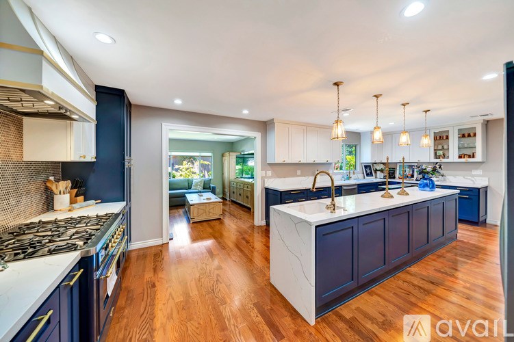 A modern kitchen with dark blue cabinets and a white countertop.