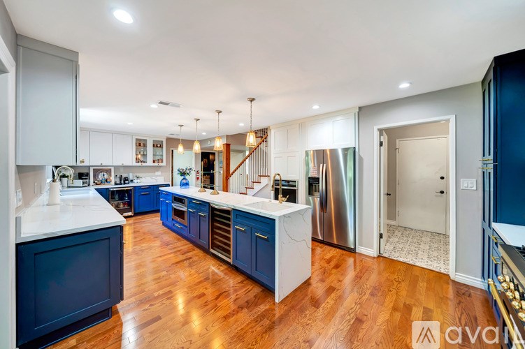 A modern kitchen with dark blue cabinets and stainless steel appliances.