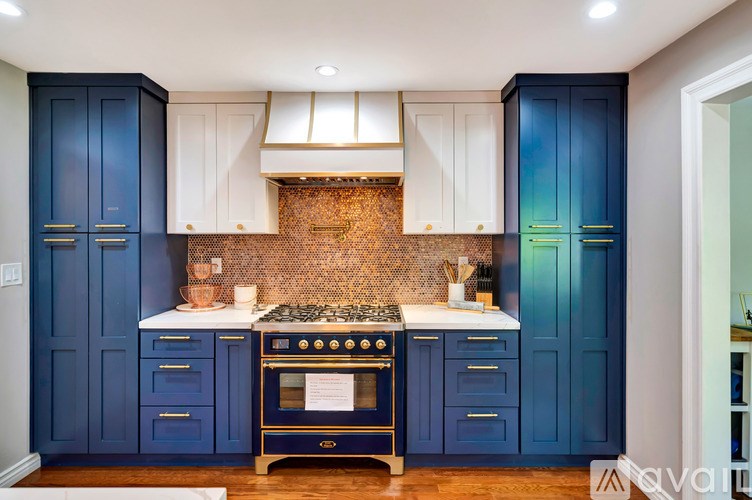 A kitchen with blue cabinets and a brick backsplash.