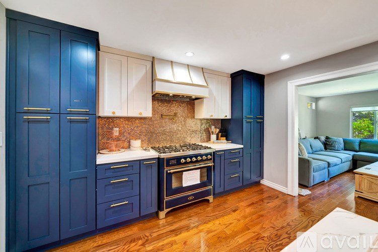 A kitchen with blue cabinets and a brick backsplash.