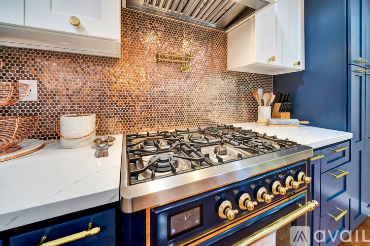 A kitchen with a stove top oven and a tile backsplash.