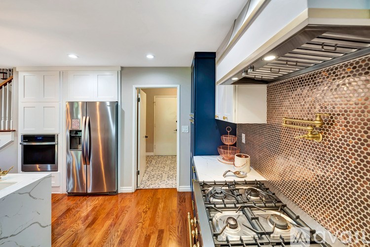 A kitchen with a stove top oven and a refrigerator.