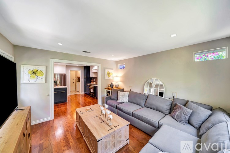 A living room with a grey couch and a wooden coffee table.