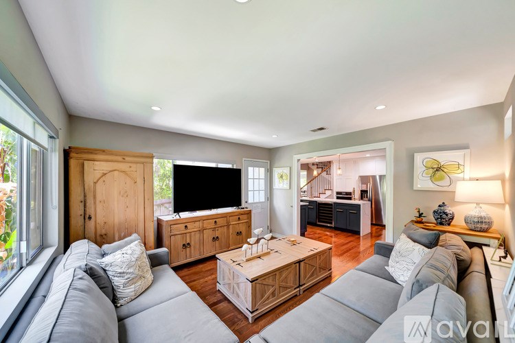 A living room with a grey sofa and a wooden cabinet.