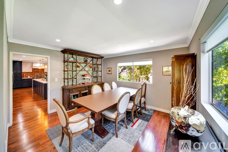 A dining room with a wooden table and chairs.