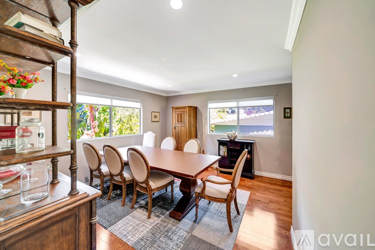 A dining room with a table and chairs.