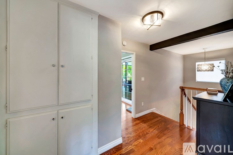 A room with white cabinets and a wooden floor.