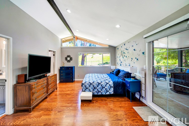 A bedroom with a bed, a dresser, and a television.