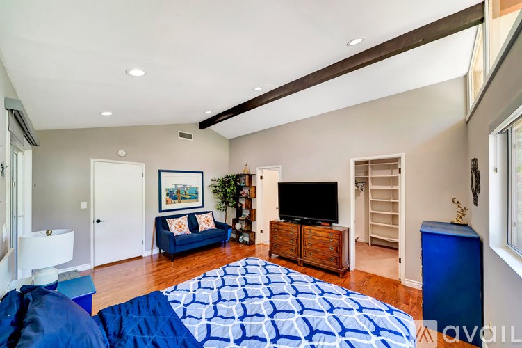 A bedroom with a large bed and a television.