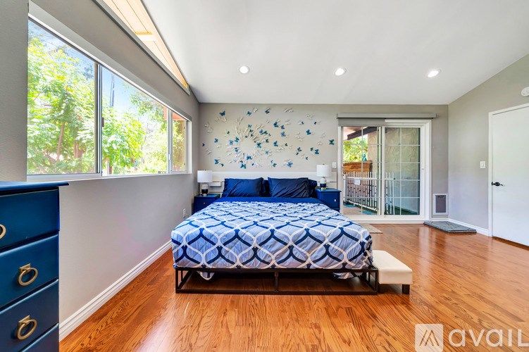 A bedroom with a bed, dresser, and a wall with blue and white decorations.