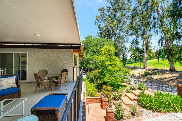 A patio with a table and chairs overlooks a garden.