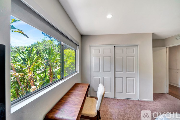 A room with a large window and a wooden bench.