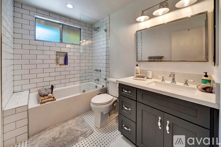 A bathroom with a white toilet, a bathtub, and a sink.