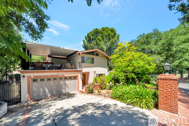 A house with a driveway and garage surrounded by greenery.