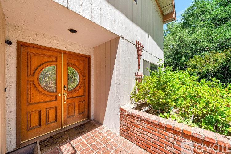 A wooden door with a glass window is set in a white wall.
