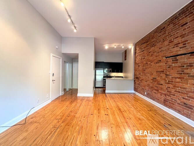 A living room with a brick wall and a television.