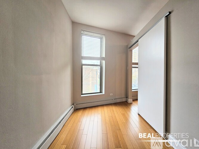 A black wood stove is in a room with a brick wall.