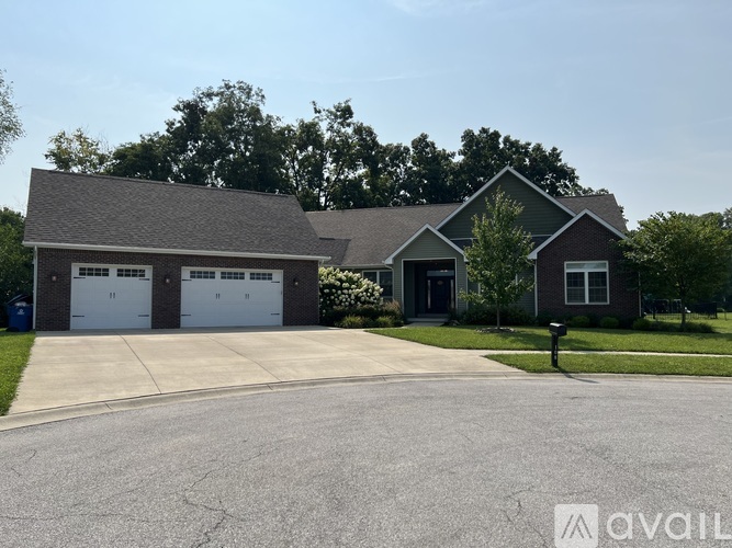 A house with a grey roof and a white garage door.