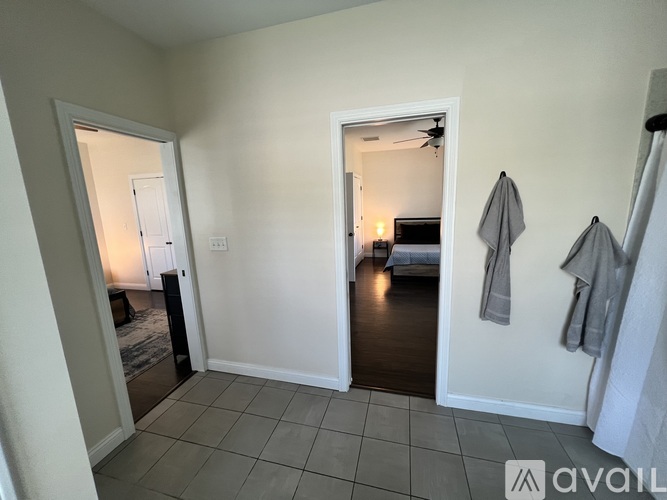 A bedroom with a bed and a fan in the corner.
