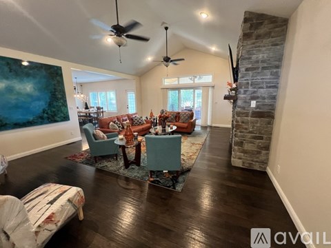A living room with a stone fireplace and a painting on the wall.