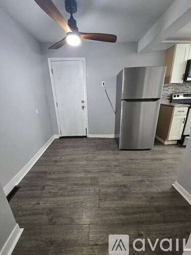A kitchen with a stainless steel refrigerator and a ceiling fan.