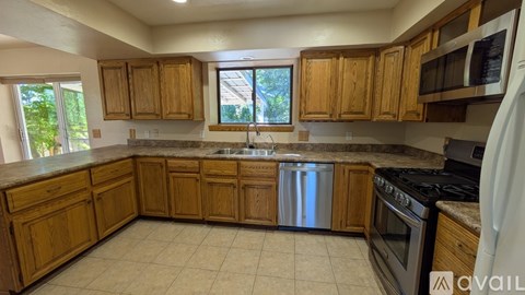 A kitchen with wooden cabinets and a stainless steel dishwasher.
